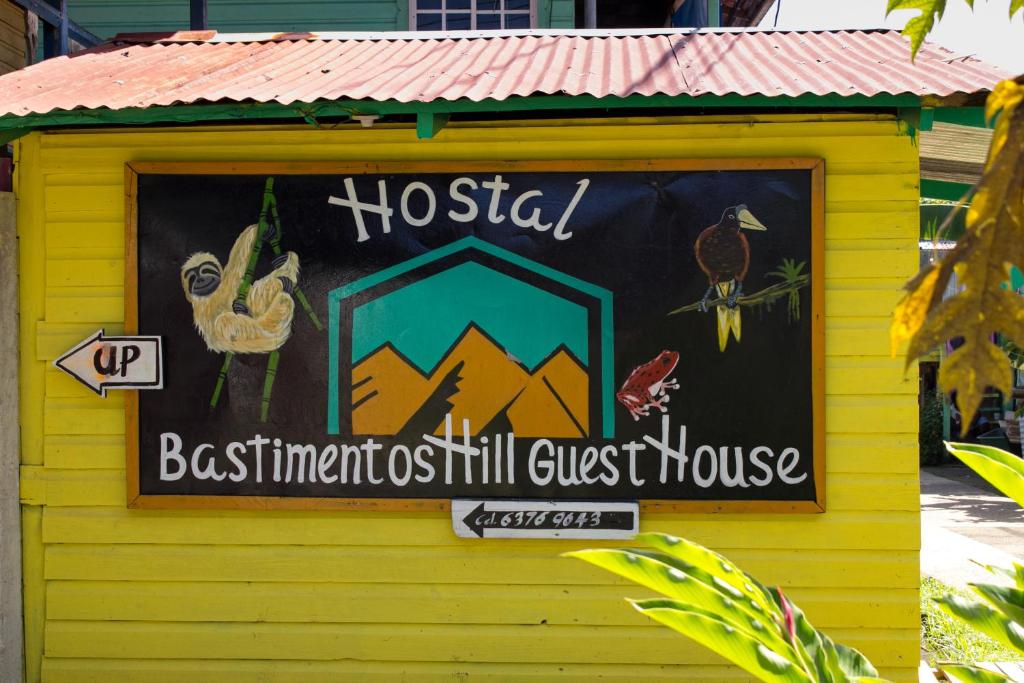 a sign for a hostel in a yellow building at Bastimentos Hill Guest House in Bocas Town