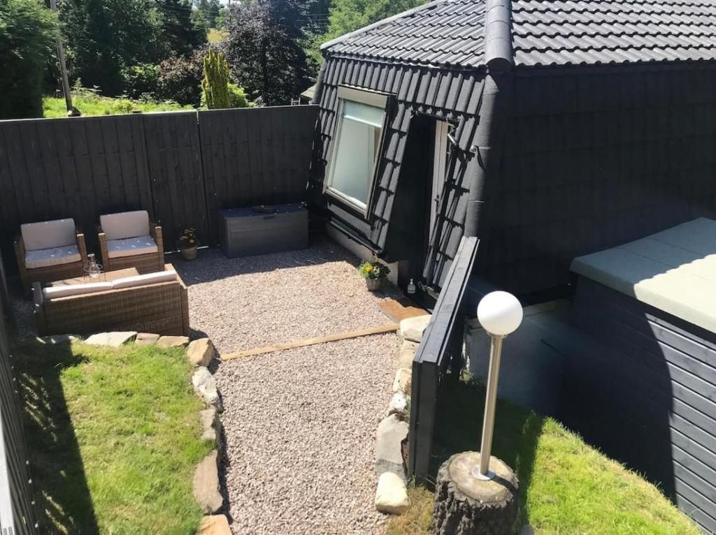 a small backyard with a bench and a fence at Riverside Hideaway in Kincraig