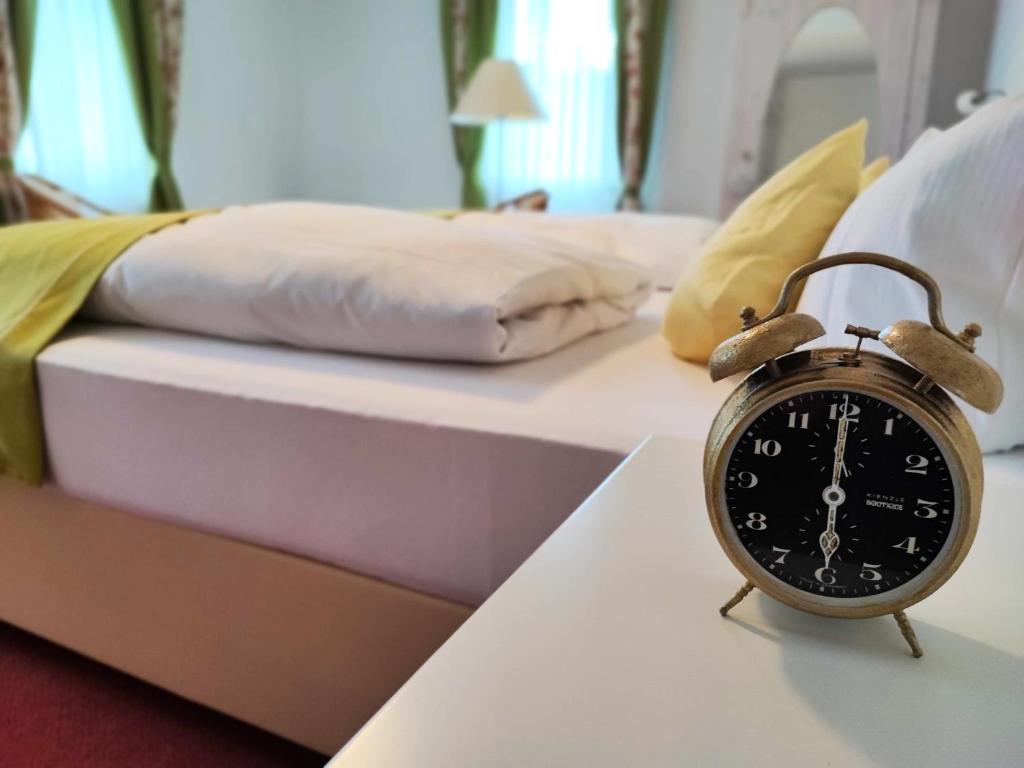 un reloj despertador sentado en una mesa junto a una cama en Room in Guest room - Pension Forelle - double room no01, en Forbach