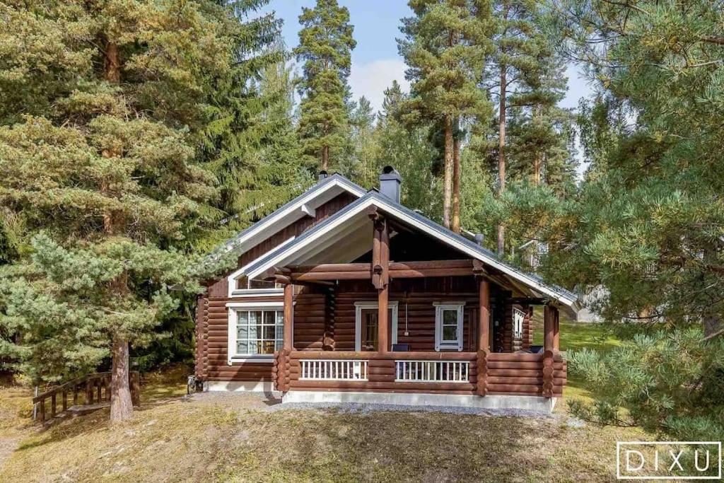 a log cabin in the woods with trees at Latvahonka Cottage in Jämsä