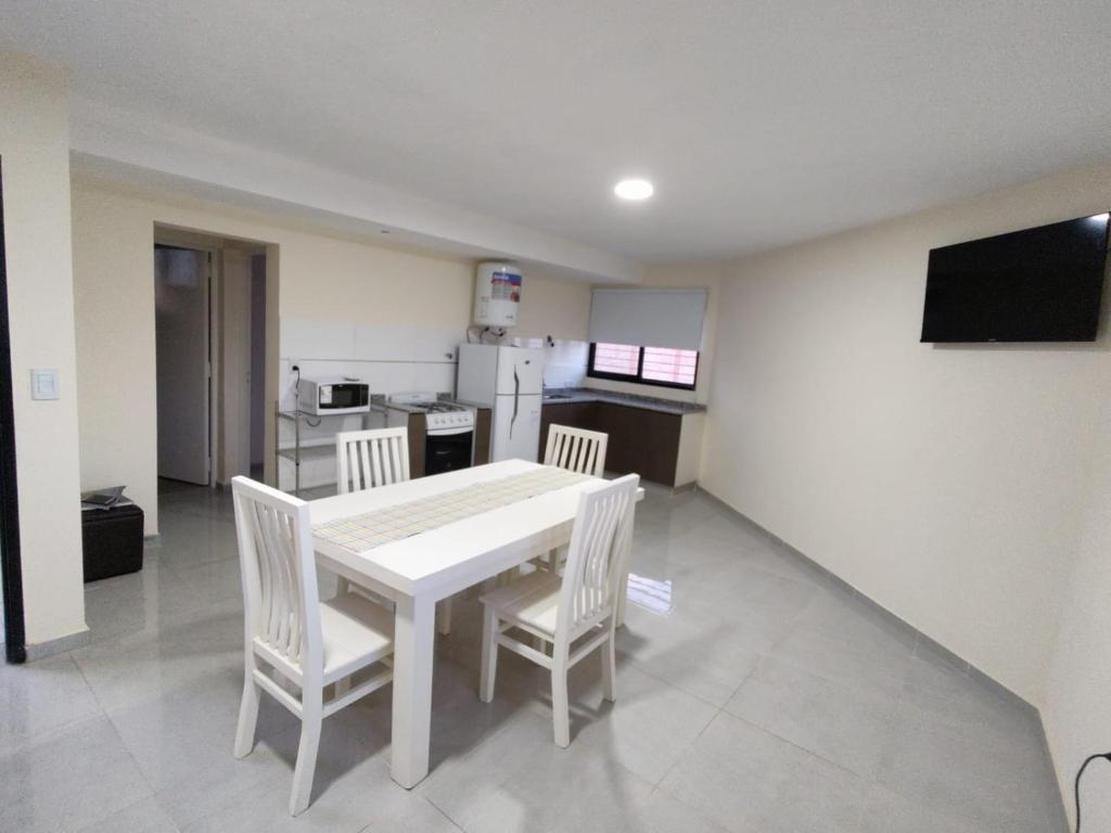 a kitchen with a white table and chairs in a room at Alpaquitay 1 in Mendoza