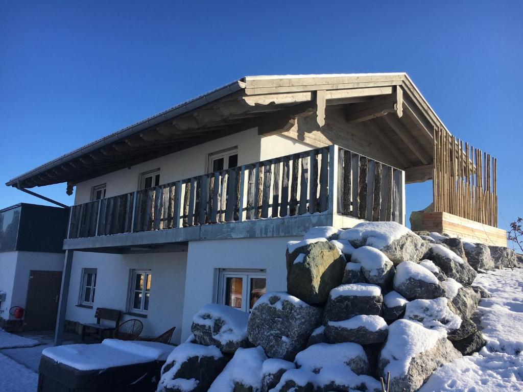 une maison avec un balcon au sommet d'un tas de neige dans l'établissement Allgäu-Chalet Kaufbeuren, à Kaufbeuren