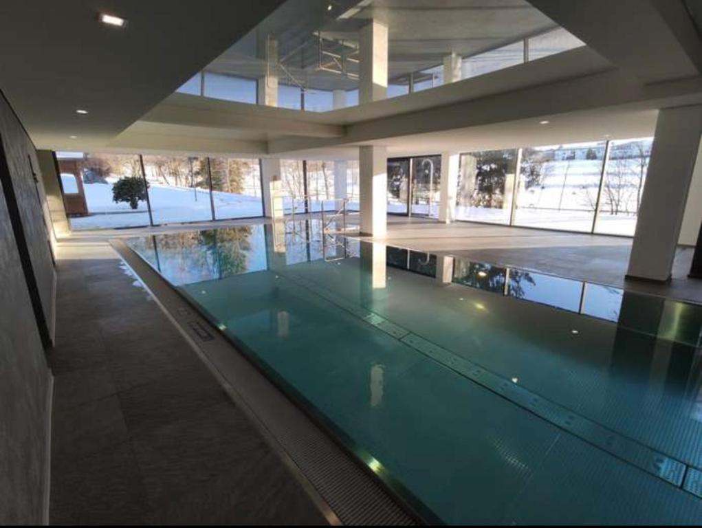 a large swimming pool in a large building with a swimming pool at MySchluchseehome Gemütliche Ferienwohnung mit Südbalkon und Pool im Haus in Schluchsee
