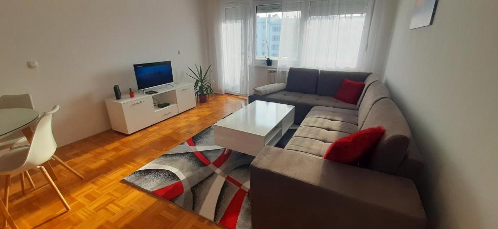 - un salon avec un canapé et une télévision dans l'établissement Apartman Stella Istočno Sarajevo, à Lukavica