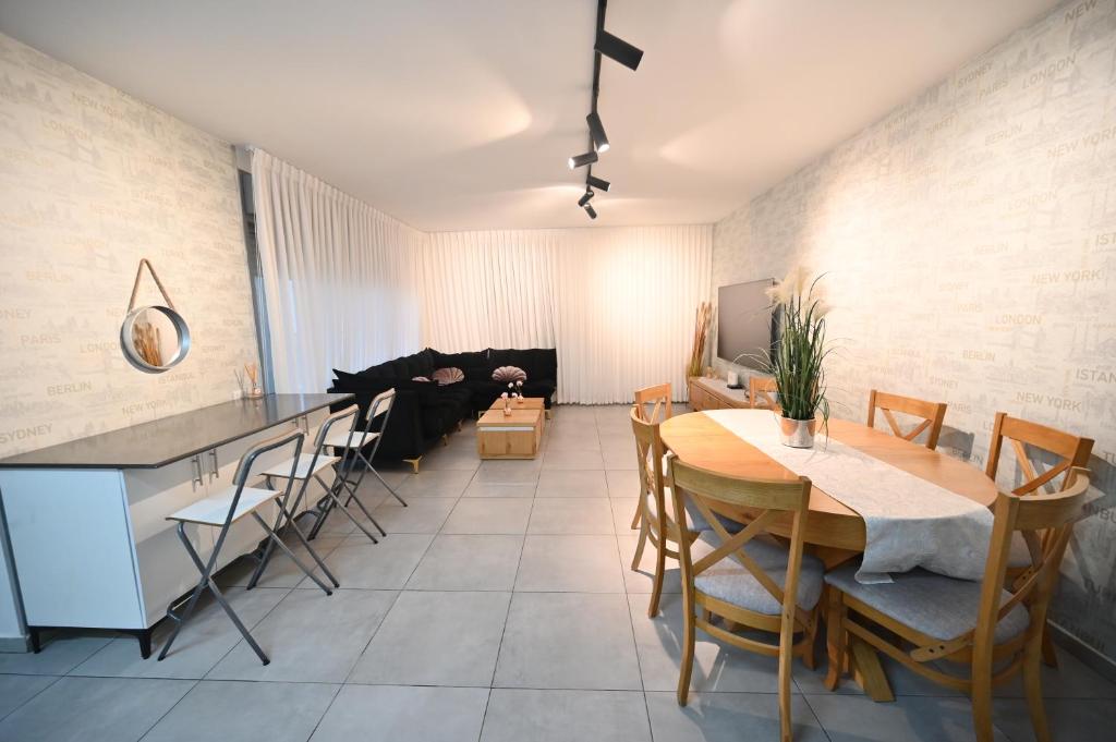 דירה luxury על הפארק חניה חינם في Migdal Afeq: مطبخ وغرفة معيشة مع طاولة وكراسي