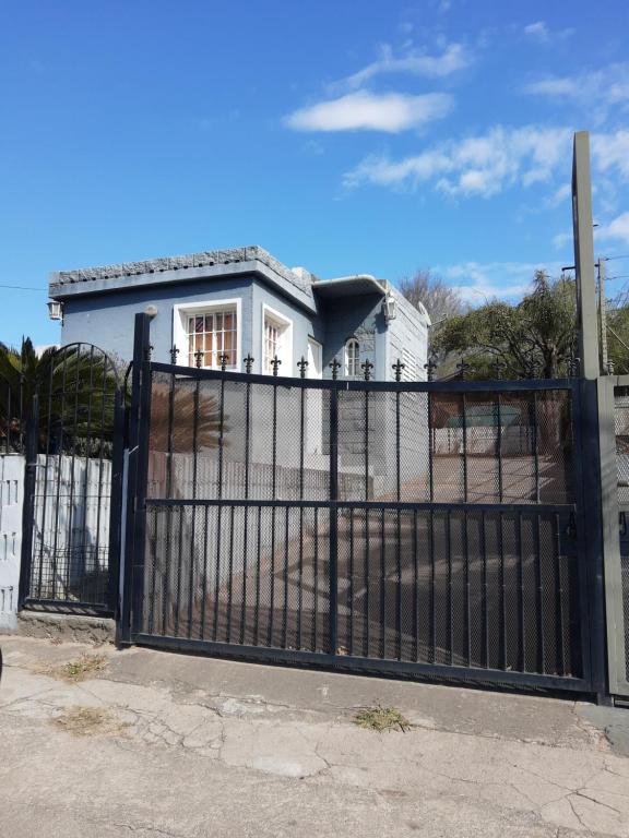 una cerca negra frente a una casa blanca en Terraza Perito Moreno, en Villa Carlos Paz