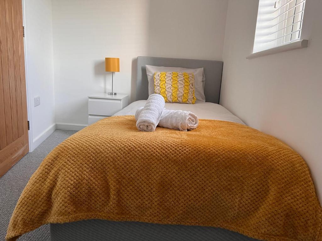 a bedroom with a bed with two towels on it at Superb modern flat in Northampton, parking &EV in Northampton