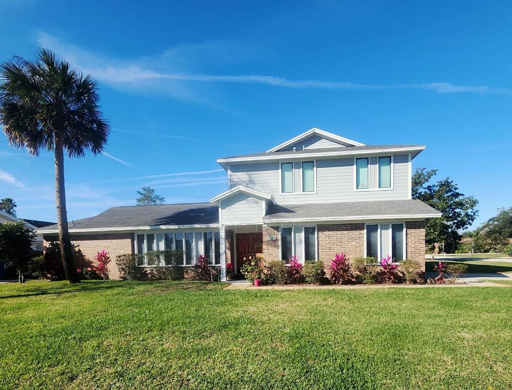 a white house with a palm tree in a yard at Apartment in Ponte Vedra Beach in Ponte Vedra Beach