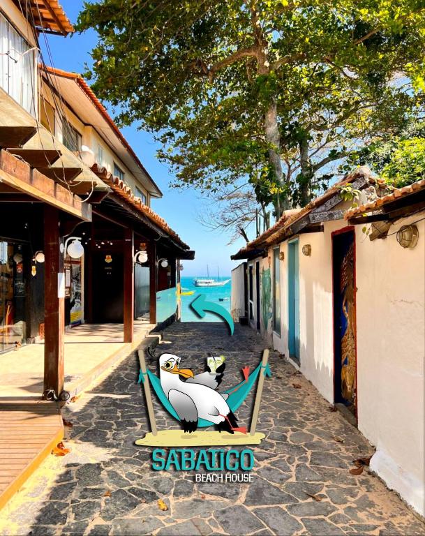 a resort logo with a penguin sitting on a chair at Sabatico Beach House in Búzios