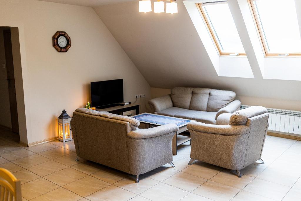 sala de estar con 2 sillas y sofá en Rodzinny apartament FOLKER, en Cisiec