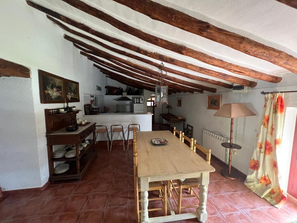 a dining room with a wooden table and chairs at Cortijo EL COSIO in Benamaurel