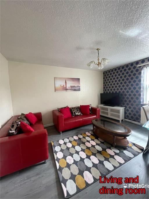 Stanley的住宿－Super deluxe extra large 3 bedroom apartment，客厅配有两张红色的沙发和地毯。