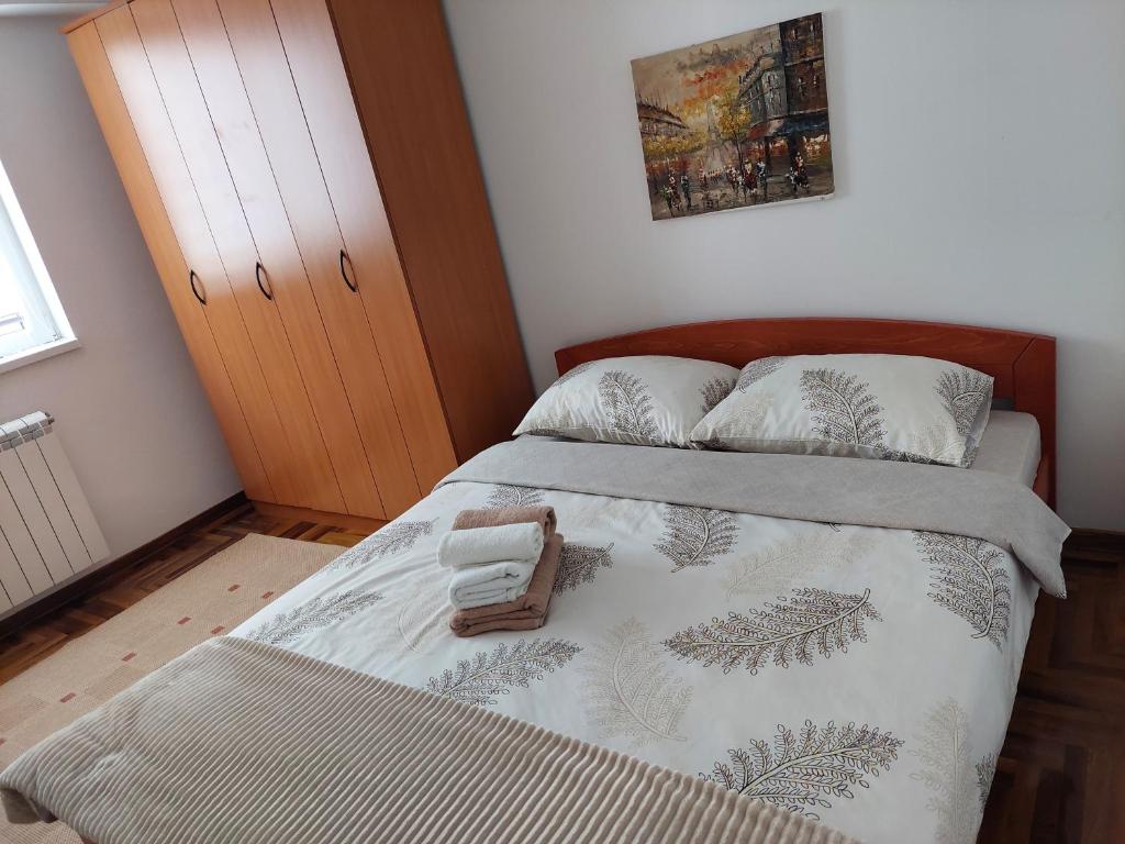 een slaapkamer met een bed met een deken en kussens bij Apartman Đorđević in Kraljevo