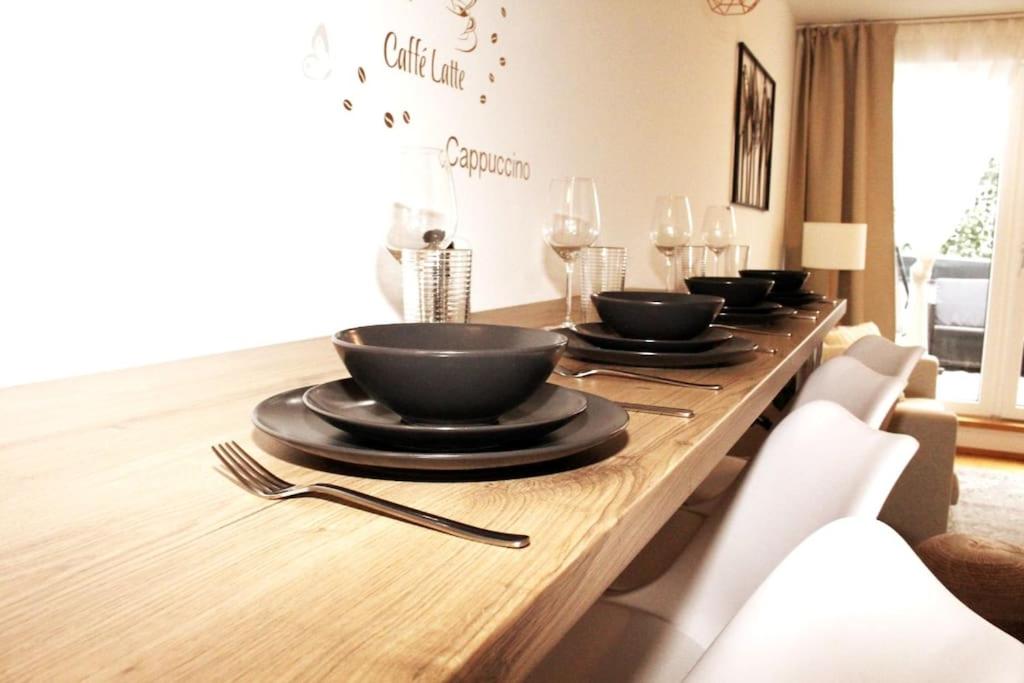 a wooden table with black bowls and plates on it at OrestaLiving - View of Vienna in Vienna