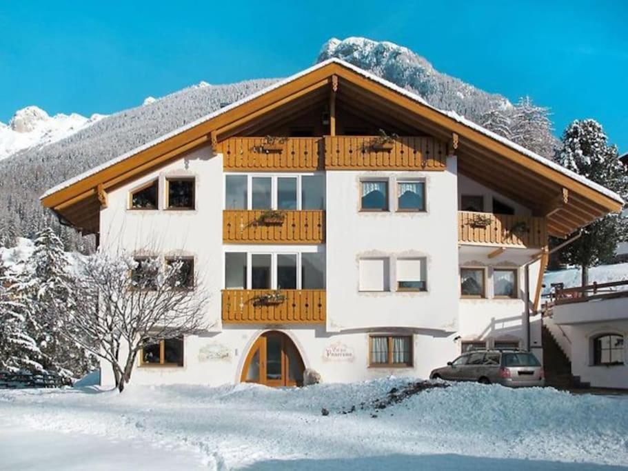 a large building with a balcony in the snow at Ciasa Gran Panorama Moena in Moena