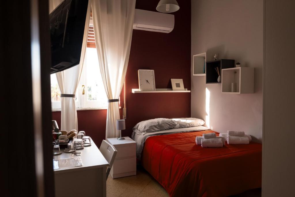 um quarto com 2 camas, uma secretária e uma janela em S&S em Palermo