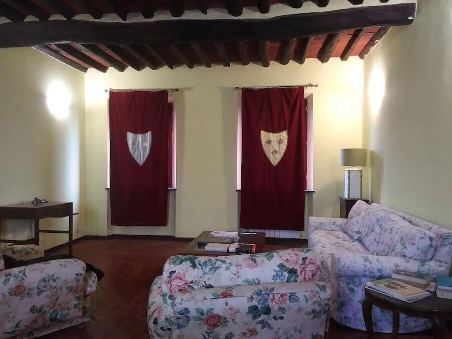 sala de estar con 2 sofás y cortinas rojas en CASA MANSI Top Class en Lucca