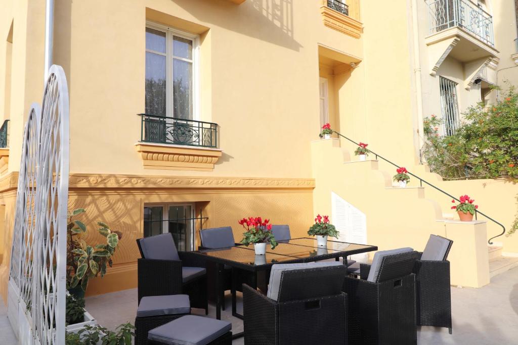 a table and chairs on a patio with a building at Maison familiale niçoise avec terrasse in Nice