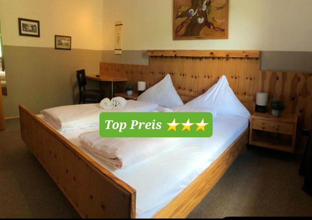 a large bed with a top prefix sign on it at Hotel Zum Deutschen Eck in Velbert