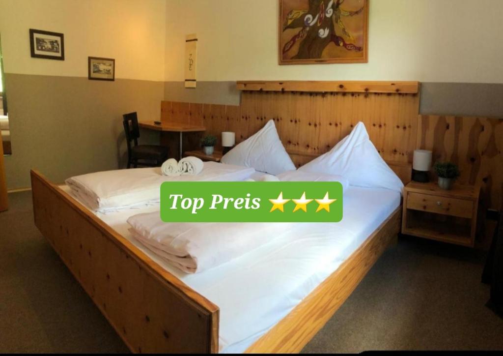 ein großes Bett mit einem Top-Präfix-Schild darauf in der Unterkunft Hotel Zum Deutschen Eck in Velbert