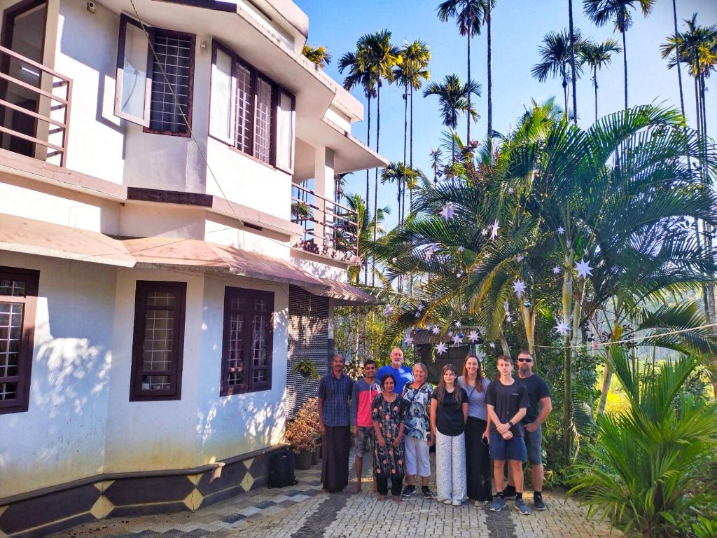 a group of people standing in front of a building at CentreHome Villa Wayanad in Meenangadi