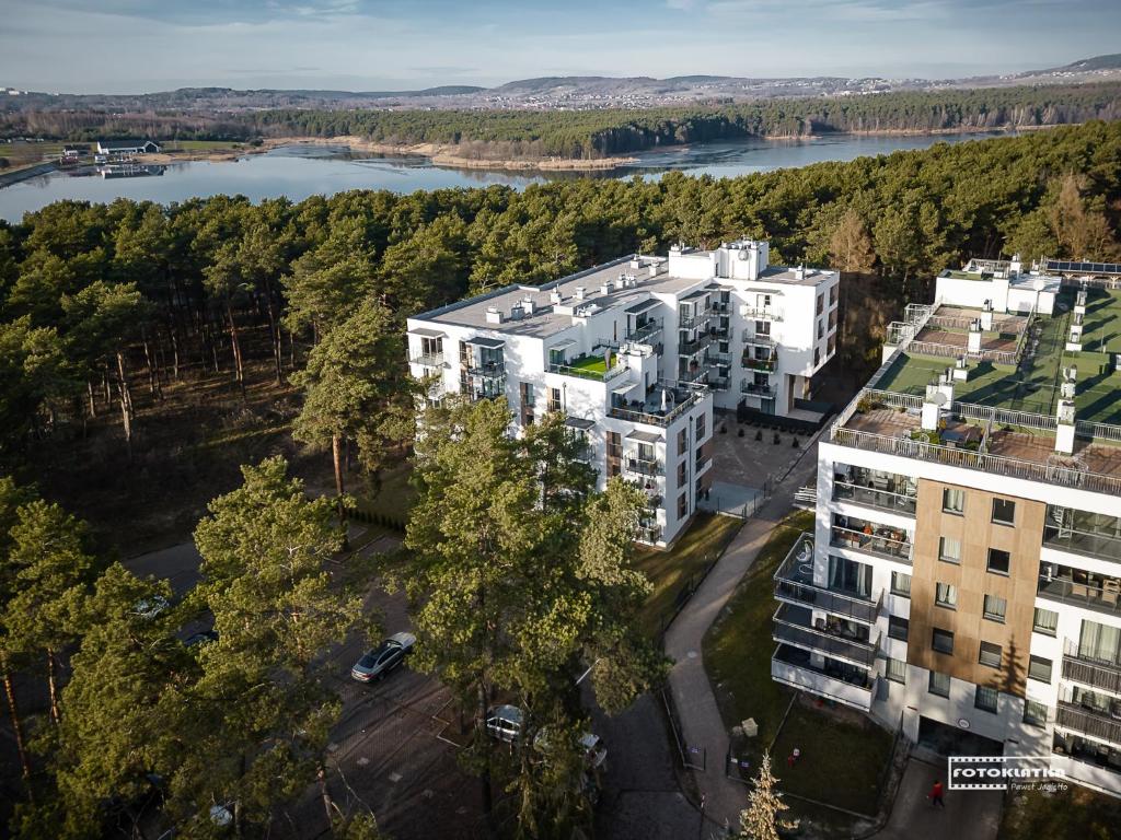 une vue sur un bâtiment avec une rivière et des arbres dans l'établissement Apartament Leśny-Cedzyna no62 TARGI Kielce Rowery !!!, à Kielce
