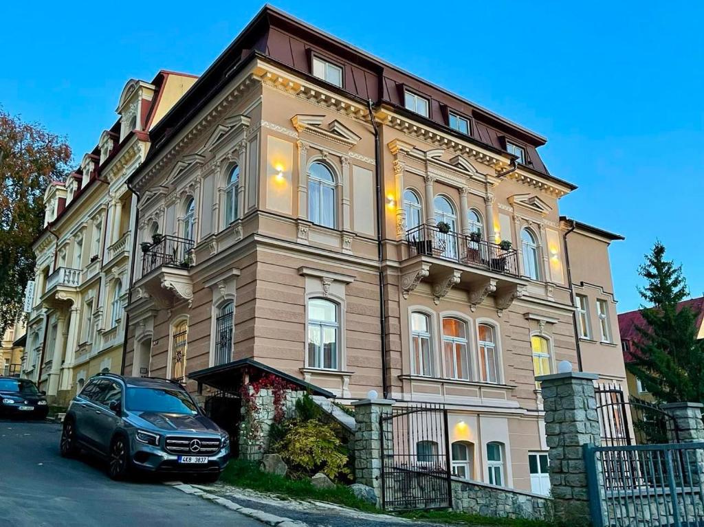 un coche aparcado frente a un gran edificio en Apartment Villa Frank en Mariánské Lázně