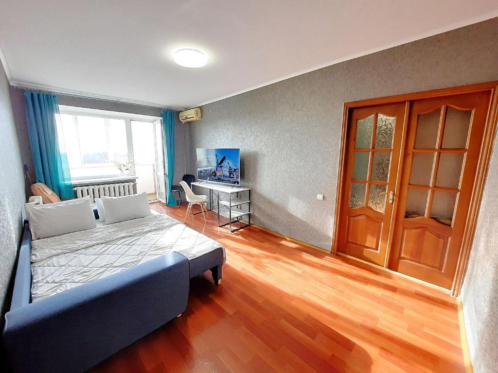 a bedroom with a bed and a desk in it at Слава Героям 11 Сеть апартаментов Alex Apartments Бесконтактное заселение 24-7 in Poltava