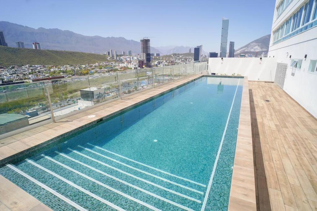 een zwembad op het dak van een gebouw bij Best Apt Luxury Modern New 2BR Gym Pool 3mins SPGG in Monterrey
