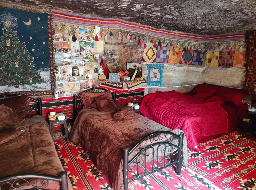 a bedroom with two beds and a christmas tree at Indiana Jones Cave in ‘Ayn Amūn