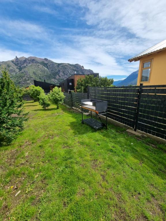 un patio trasero con un banco en el césped en Lomas Schuss ARG41 en San Carlos de Bariloche
