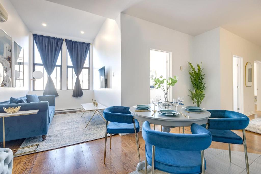 - un salon avec une table et des chaises bleues dans l'établissement M11 Gorgeous 3BR wKingBed Perfect Location, à Montréal