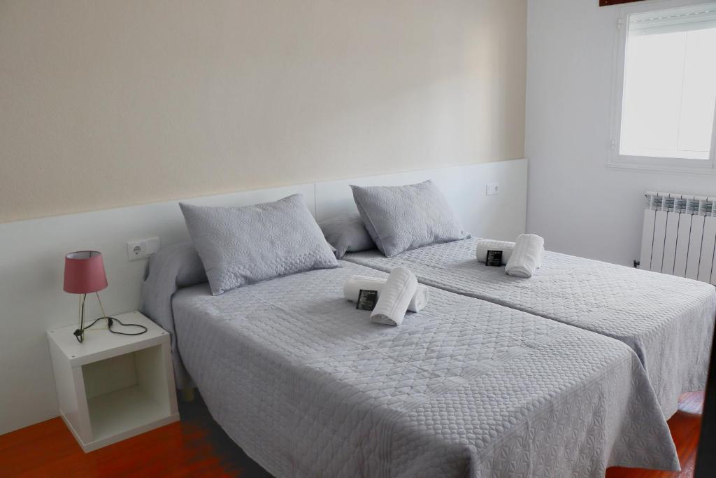 a bedroom with two beds with towels on them at dpCristal Sarria Centro in Sarria