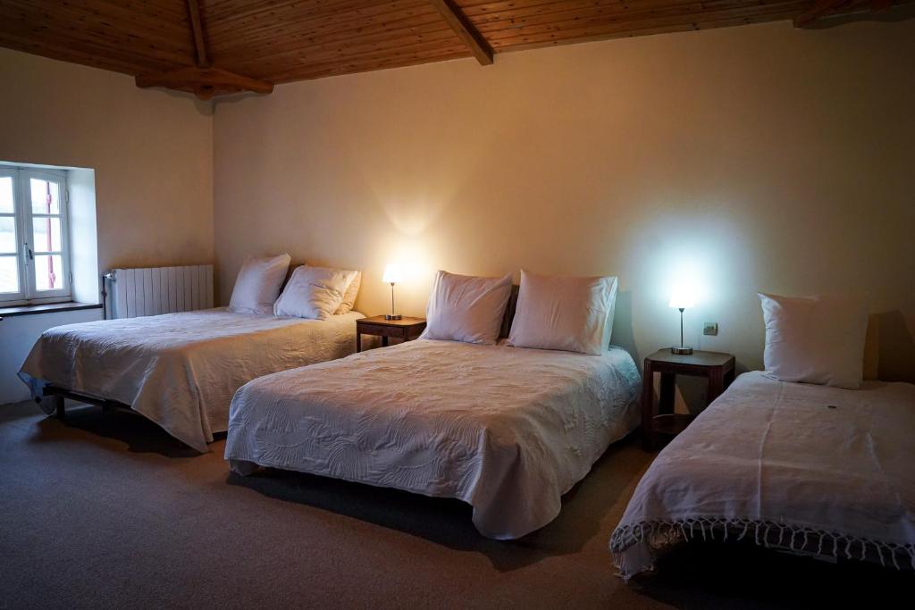 two beds in a room with two lamps on tables at Chambre familiale 5 personnes in Rouffignac