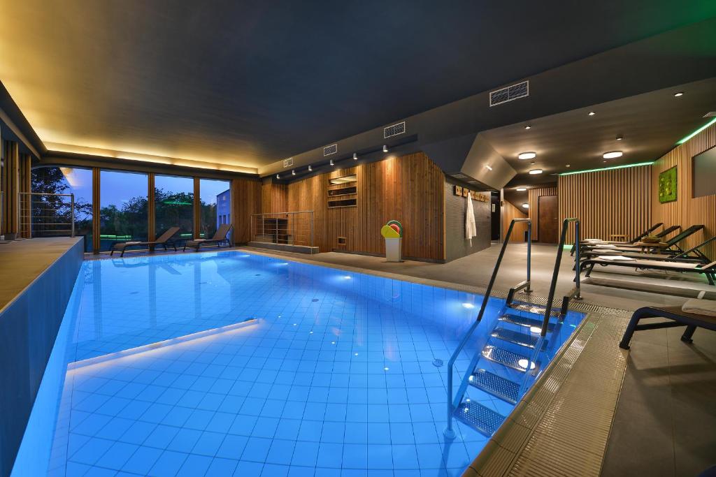 a large swimming pool in a house at Maxmilian Lifestyle Resort in Loučeň