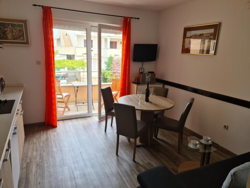 a living room with a table and chairs and a balcony at Apartman Branka in Povljana