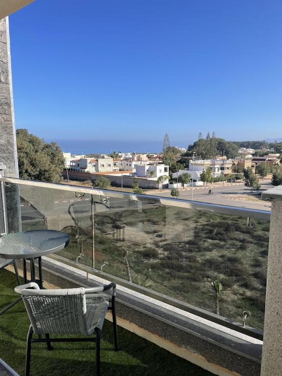 a balcony with a table and a view of a street at Appartement haut standing in Saïdia