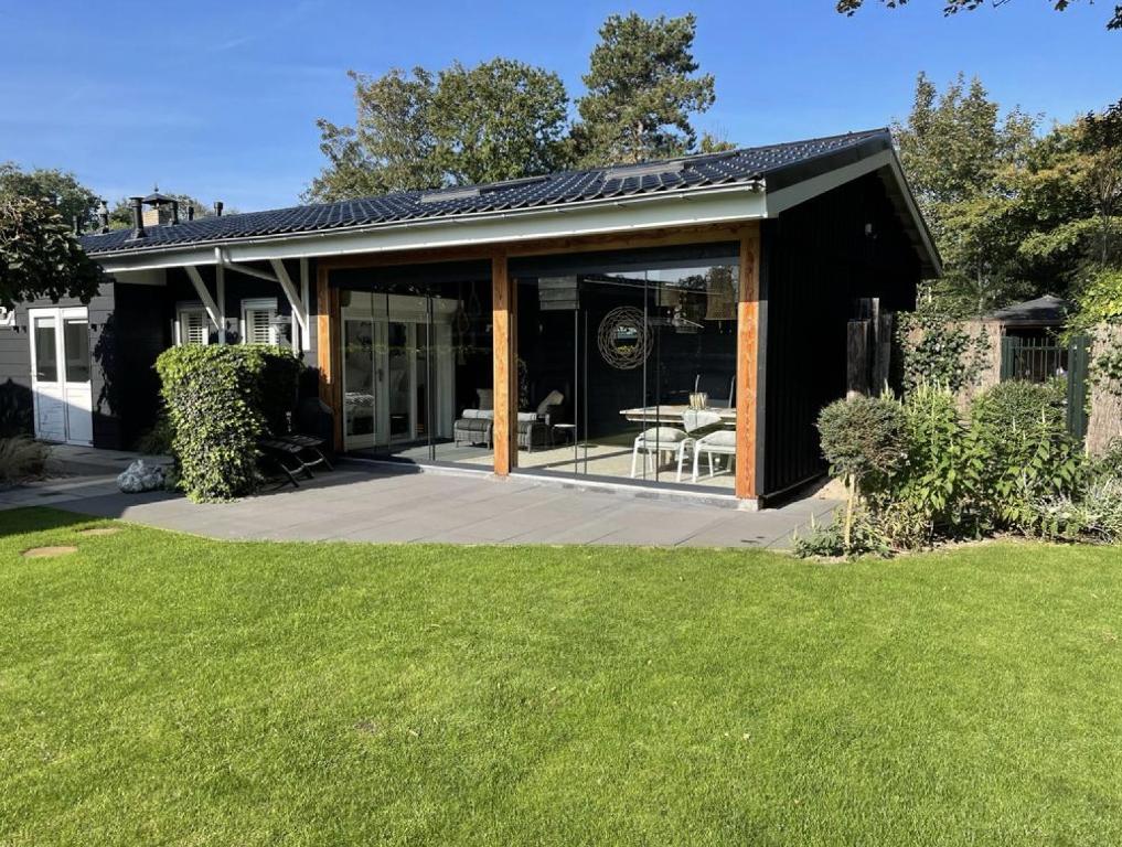 une maison avec des portes en verre et une terrasse dans l'établissement Tussenrenesseenstrand, à Renesse