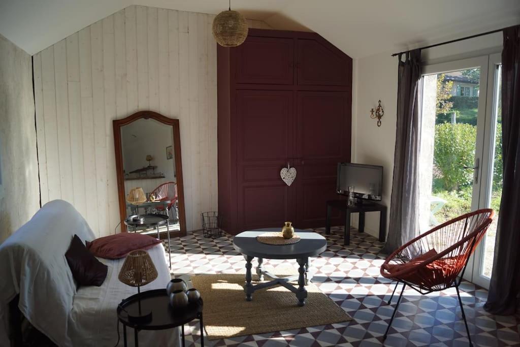 sala de estar con cama, mesa y sillas en Petite longère du Clos Madeleine en Vincelles