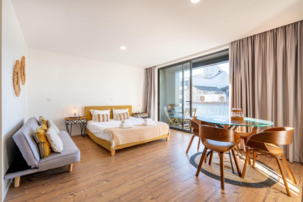 uma sala de estar com uma cama e uma mesa de vidro em in the MOOD no Porto
