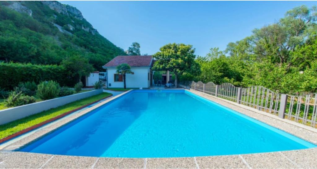 uma piscina com água azul em frente a uma casa em Holiday Home Harmony em Mostar