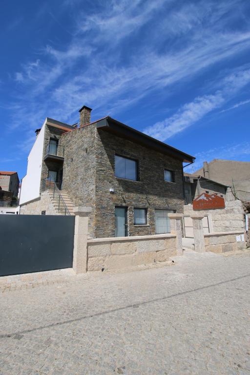 ein Backsteinhaus mit blauem Himmel im Hintergrund in der Unterkunft Afonsos House & Rooms in Videmonte