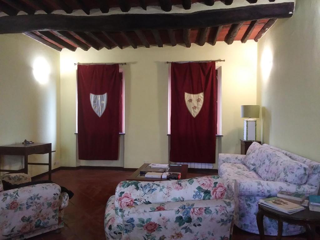 ein Wohnzimmer mit 2 Sofas und roten Vorhängen in der Unterkunft CASA MANSI ROOMS AND HOSPITALITY in Lucca