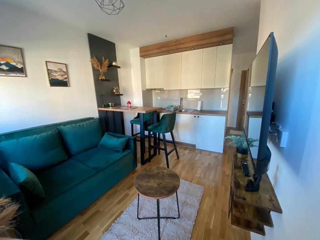 een woonkamer met een groene bank en een tafel bij Zlatiborika Spa&Lux Apartment in Zlatibor