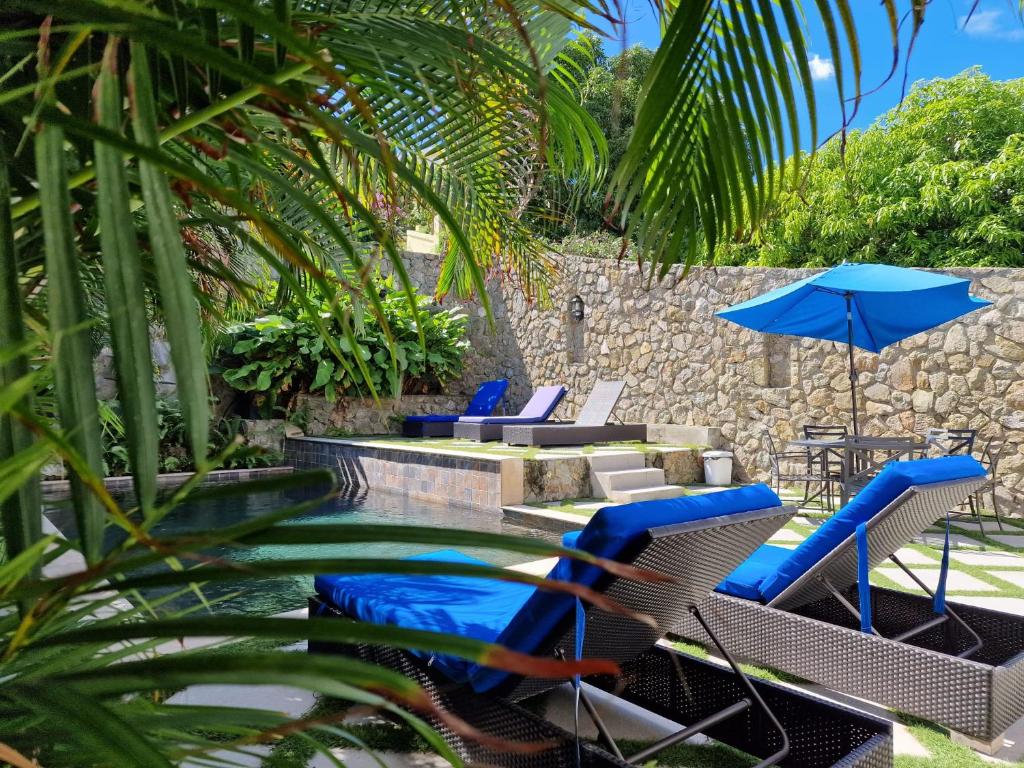 een zwembad met stoelen en parasols naast een zwembad bij OASIS 1 Bedroom Apartment Simpson Bay in Simpson Bay