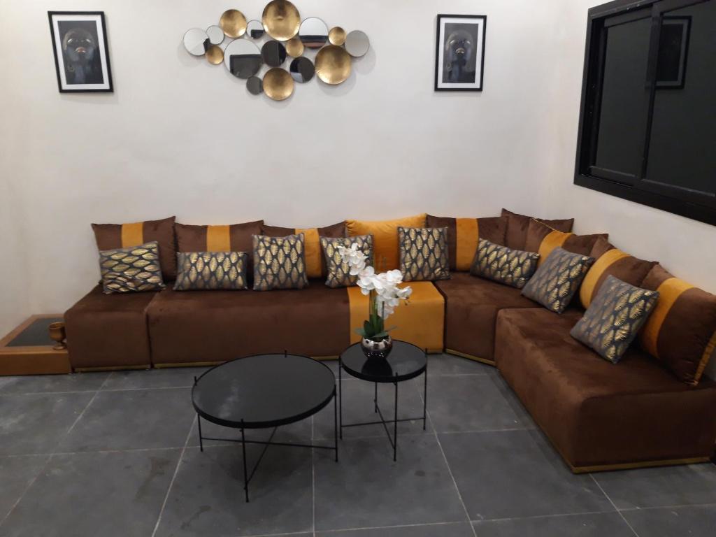 ein Wohnzimmer mit einem braunen Sofa und einem Tisch in der Unterkunft Résidence Edelweiss in Dakar