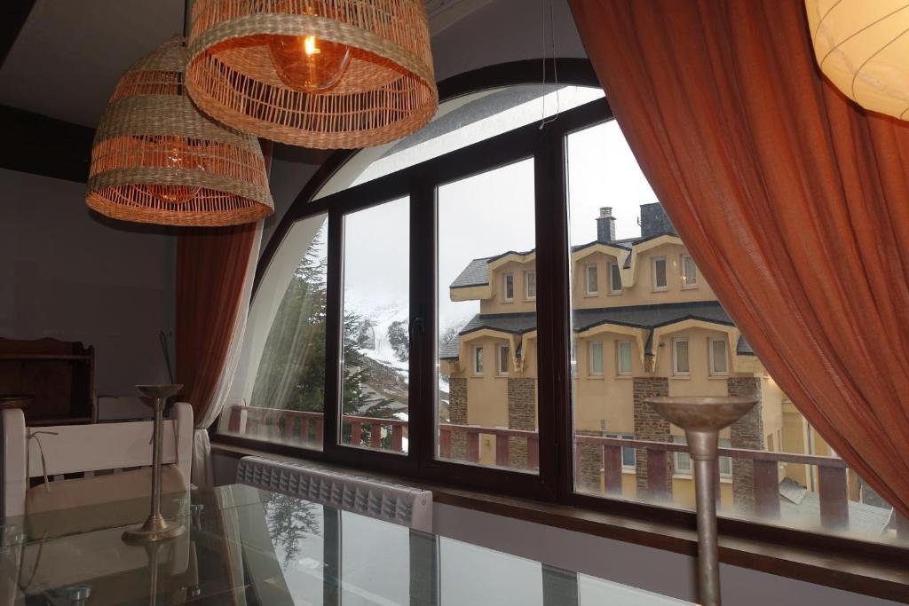 a large window with a view of a building at Casa acogedora en Sierra Nevada in Monachil