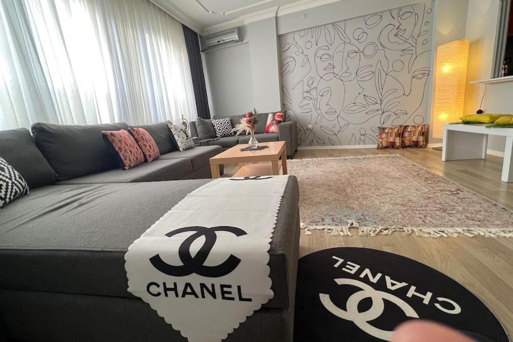 a living room with a couch and a chanel sign at Rahatlık şıklık ve konfor in Çekirge