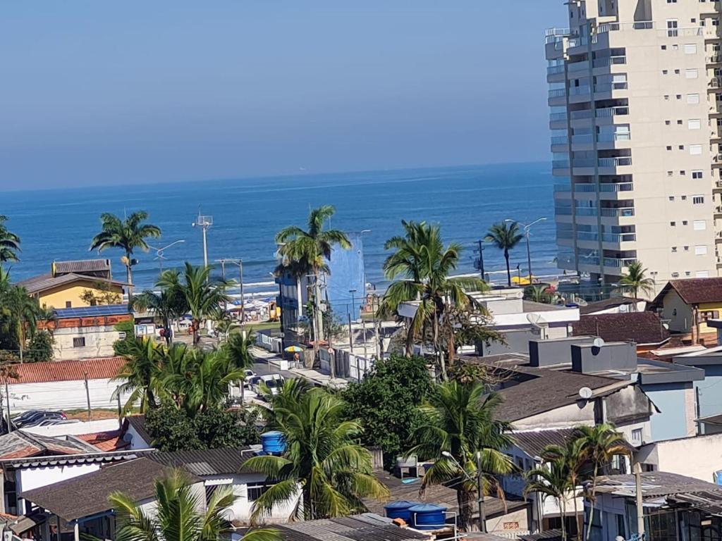 a city with buildings and palm trees and the ocean at COBERTURA VISTA PARA MAR - WI-FI, PISCINA, AR - Disponível Páscoa - 29-03 in Bertioga