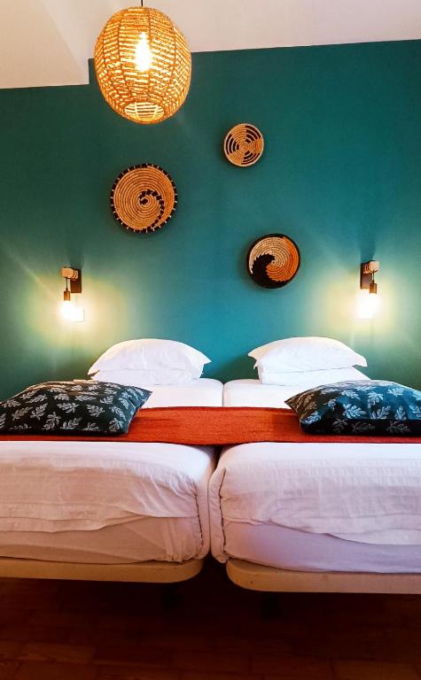 two twin beds in a room with a green wall at Aveiro Rossio Lodge in Aveiro